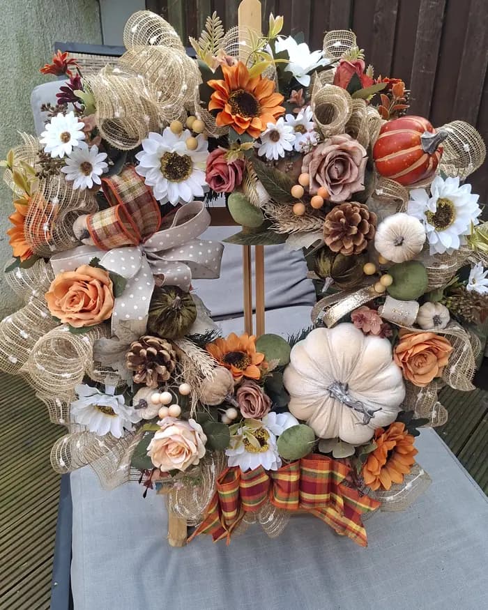 An autumn wreath with sunflowers, white and orange pumpkins, hessian and tartan ribbon.